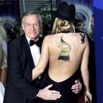 El fundador de la revista Playboy, Hugh Hefner posa junto a una de sus "conejitas" durante la 44ª edición anual de los Premios Grammy en Los Angeles, en 2002.