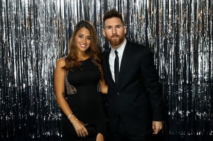 Lionel Messi  y su esposa Antonela Roccuzzo, ella vestida con un traje negro de Rosa Clará.