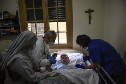 Félix Murillo es atendido por el médico Juan José Unzue y la enfermera Karen Oses, mientras es vacunado contra el coronavirus en el asilo religioso El Buen Pastor, en Pamplona, España. Este viernes entran en vigor las nuevas medidas adoptadas por el Gobierno de Navarra ante el aumento de la covid, que contemplan el adelanto del cierre de la hostelería en una hora, a las 21:00, y la prohibición de fumar en terrazas y "barriles" a las puertas de los locales, así como consumir cigarrillos en movimiento por la calle.