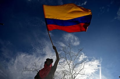 Un hombre sostiene la bandera colombiana.