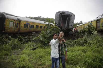 Dos jóvenes indios se hacen una fotoi junto a varios vagones del tren Duronto Express que descarrilaron en Asangaon, a 70 kilómetros de Bombay (India).