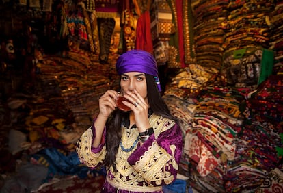 Una mujer afgana vestida con ropa tradicional posa mientras toma té. Foto de la colección 'Perla en la ostra'.