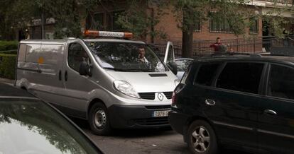 Empleados de la funeraria trasladan el cuerpo de la mujer fallecida.