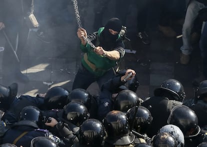 Un manifestante radical empuña una larga cadena con la que se dispone a atacar a los policías en el Día de los Cosacos de Ucrania, el 14 de octubre, que propició nuevos enfrentamientos entre opositores y fuerzas del orden ucranias.