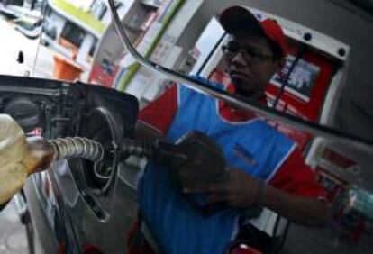 Un empleado de una gasolinera llena el depósito de un vehículo. EFE/Archivo