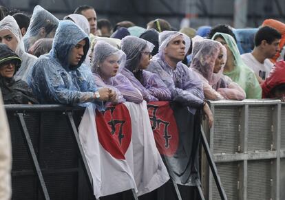 Asistentes del festival, con chubasqueros debido a las fuertes lluvias de ayer, jueves 6 de julio.