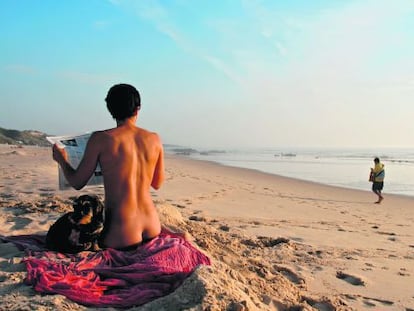 A young woman and her dog on the Portuguese beach of Malhao.