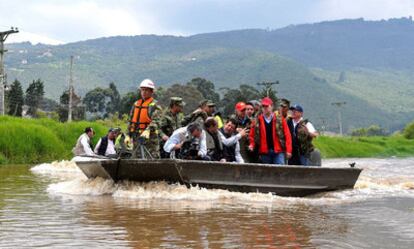 El presidente de Colombia, Juan Manuel Santos (derecha), navega por las aguas desbordadas del río Bogotá en la zona rural de Chía (Colombia). Este país pedirá en la cumbre de Durban "acciones concretas" de los Estados para reducir las emisiones de carbono.