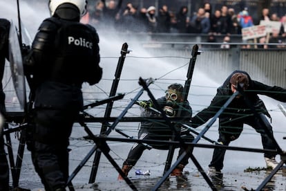 Según recogen los medios locales de Bruselas algunas personas han lanzado bengalas contra la policía, así como vandalizado algunos vehículos policiales, y habría algunos agentes heridos. En la imagen, enfrentamientos entre los manifestantes y las fuerzas de seguridad, este domingo en Bruselas.