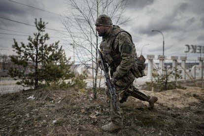 Un militar ucranio busca una posición de tiro en una carretera cercana a la localidad de Irpin, una ciudad dormitorio de Kiev, a 25 kilómetros de la capital. Los vecinos de Irpin llevan varios días intentando abandonar la ciudad ante el recrudecimiento de los combates.