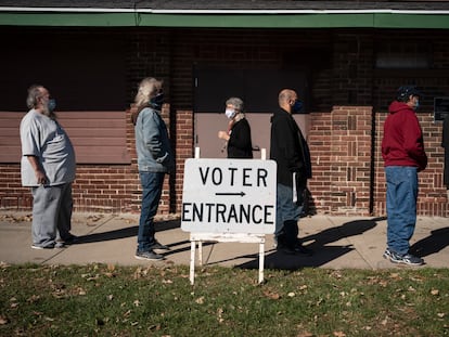 Voters wait in line outside a polling center on Election Day, Nov. 3, 2020, in Kenosha, Wis.