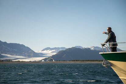 El presidente Barack Obama mira el glaciar del Oso, que ha retrocedido 1,8 millas en aproximadamente 100 años, durante un viaje en barco para ver los efectos del calentamiento global en Alaska.