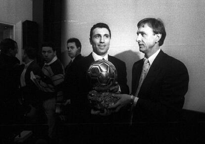 Hristo Stoichkov, ganhador da Bola de Ouro em 1994, olha enquanto Cruyff posa com o prêmio para a imprensa em Paris.