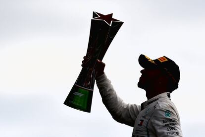 El piloto británico Lewis Hamilton alza el trofeo del Gran Premio de Italia.