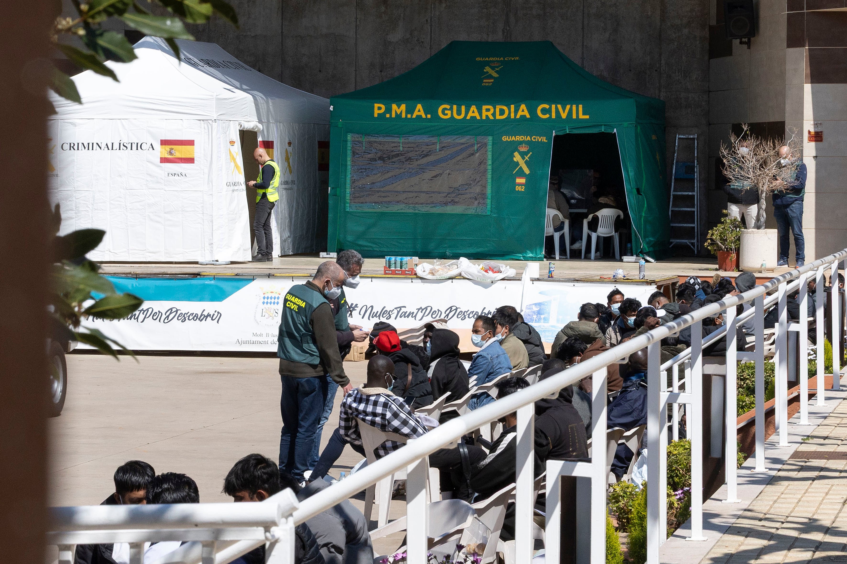 Algunos de los trabajadores liberados aguardan junto a agentes de la Guardia Civil.