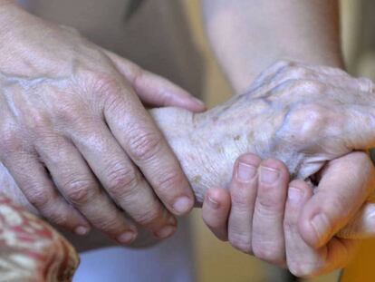 Una persona atiende a una anciana.