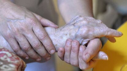 Una persona atiende a una anciana.