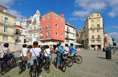 Cicloturistas en una visita guiada por el barrio lisboeta de Alfama (Portugal). 