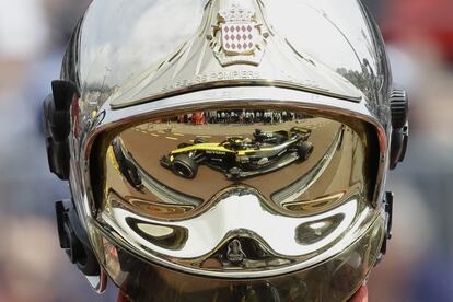 El coche del alemán Nico Hulkenberg, de Renault, se ve reflejado en un casco de bomberos, en Mónaco.