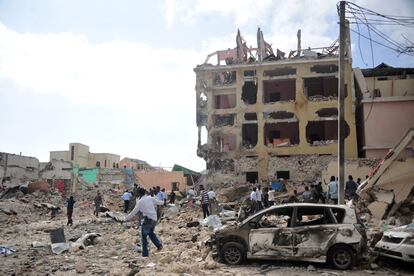 La gente reacciona y camina entre escombros tras un ataque con dos coches bomba en un hotel de Mogadiscio (Somalia) que ha dejado al menos siete muertos. El suceso ha sido reclamado por el grupo terrorista Al-Shabbaab, relacionado con Al-Qaeda.