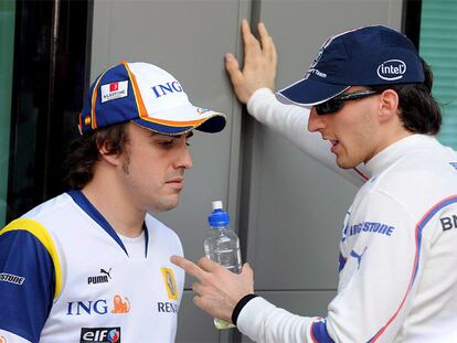 Fernando Alonso conversa con Robert Kubica ayer en el circuito de Melbourne.
