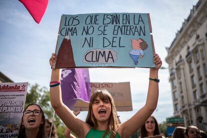 "Los que están en la cima no se enteran ni del clima" es el lema que porta una joven durante la manifestación del Sindicato de Estudiantes, este viernes en Madrid.