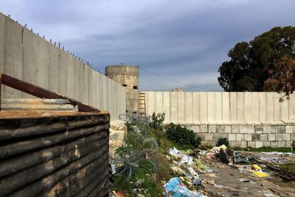 Desperdigados entre los 11 campos de refugiados palestinos que alberga Líbano, el de Ein el Helwe, cercano a la sureña ciudad de Sidón, parece a primera vista un centro penitenciario. En esta microciudad de kilómetro y medio cuadrado se hacinan 75.000 personas en uno de los pedazos del mundo más densamente poblados. Construido en 1948 tras la creación unilateral del Estado de Israel, lo que en este lado de la frontera se conoce como la Naqba (catástrofe), los refugiados y sus descendientes viven cercados por muros y vayas. Las cuatro únicas entradas y salidas del campo son custodiadas por soldados libaneses. En este agujero y dependientes de las ayudas de la ONU, conviven hasta cuatro generaciones fruto del éxodo forzado. Hay ancianos que han nacido, vivido y muerto entre sus muros. Los barrios han sido bautizados mimetizando las regiones de origen de los refugiados. Las dos únicas calles transitables por vehículos parten el campo en dos y reflejan la misma división política que separa Gaza de Cisjordania. En la calle de arriba gobiernan Fatah y sus aliados. En la de abajo lo hacen Hamás y los grupos islamistas. Los muros, legales, sociales y físicos, torpedean la vida de los 400.000 refugiados palestinos que habitan en el diminuto país (representado un 10% de la población total). Conscientes de que nunca podrán franquear los 62 kilómetros que separan Ein el Helwe de Palestina, las nuevas generaciones truecan el sempiterno discurso del derecho al retorno por la más factible héjira. Saben que su única oportunidad para pisar la tierra que solo conocen por boca de sus abuelos, es cruzar ilegalmente los 1.600 kilómetros de fronteras que les separan de las costas europeas, y, una vez allí, soñar con un pasaporte que les permita viajar como turistas a la tierra de sus ancestros./ NATALIA SANCHA (Beirut)