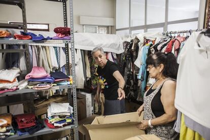 Dos voluntarias preparan la ropa donada para repartir entre los vecinos que la necesiten en un local del barrio. La ropa de niños y bebés es la más solicitada.
