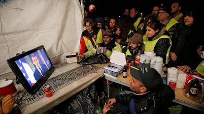 Un grupo de chalecos amarillos sigue el mensaje de Emmanuel Macron. 
 