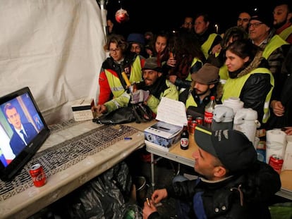 Un grupo de chalecos amarillos sigue el mensaje de Emmanuel Macron. 
 