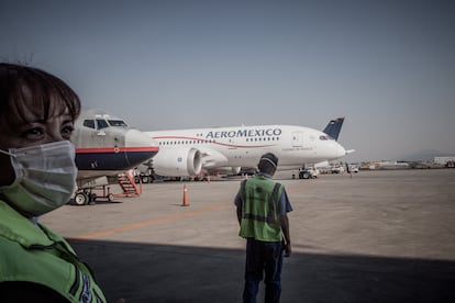 Trabajadores de Aeroméxico delante de un avión en el Aeropuerto Internacional de Ciudad de México.