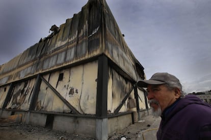 Un trabajador frente a la empresa Vallesp&agrave; totalmente calcinada