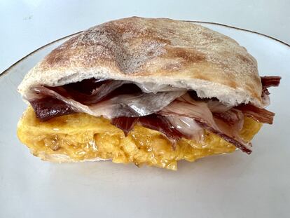 Tortilla de patatas de bolsa, con jamón ibérico y entre un pan de mollete.