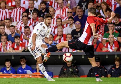 El defensa del Athletic de Bilbao Óscar De Marcos intenta desviar un balón del delantero del Real Madrid Marco Asensio.
