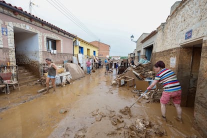 Vecinos de Letux (Zaragoza) retiran el barro de sus domicilios, este sábado.