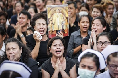 Mujeres tailandesas lloran durante la procesión del féretro con los restos mortales del retrato del rey Bhumibol de Tailandia.