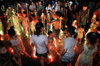 Niños jugando en una fuente con luces de colores durante una ola de calor en Yangzhou (China)
