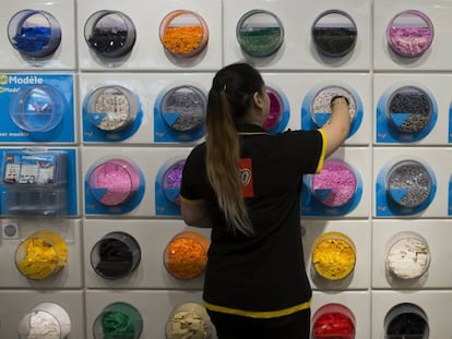 Una empleada coloca piezas de Lego en los estantes de una tienda