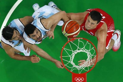 Luis Scola (izquierda) y Roberto Acuna (centro) del equipo Argentino, Darko Planinic (Croacia) disputan el partido del Grupo B de baloncesto.