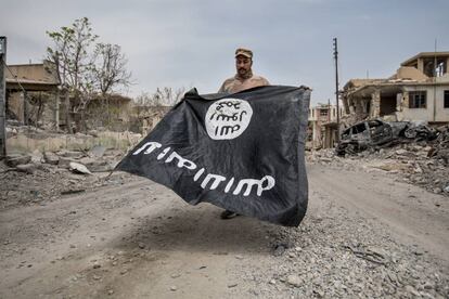 Un soldado del ejército iraquí presenta una bandera del ISIS encontrada en un hospital en Mosul.