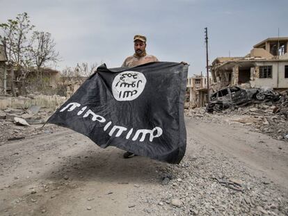 Un soldado del ejército iraquí presenta una bandera del ISIS encontrada en un hospital en Mosul.