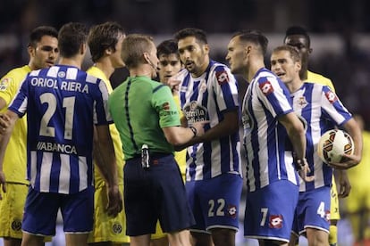 Los jugadores se agolpan en torno al árbitro.