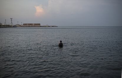 Raúl Navas, de 25 anos, toma banho no Lago Maracaibo no final do dia de trabalho no mercado municipal. Neste lago, o maior da América Latina, já se alertou para a grave contaminação por mais de cinco anos perante a Comissão Permanente de Meio Ambiente, Recursos Naturais e Mudanças Climáticas da Assembleia Nacional. 300 quilômetros da costa foram afetados pelo derramamento diário de até 70 barris de petróleo no estuário.