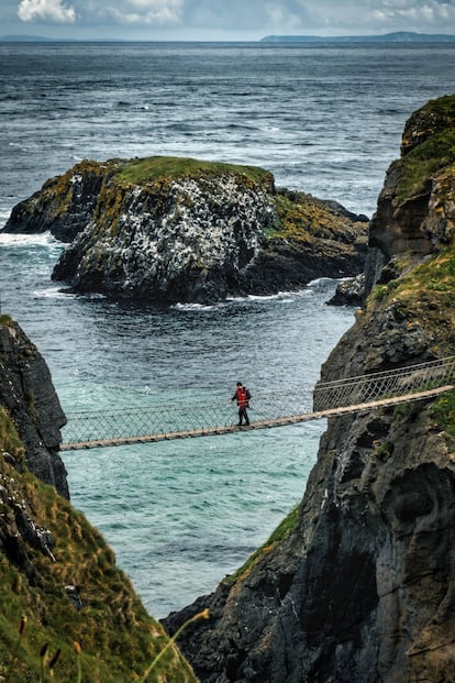 Una persona cruzando el puente colgante Carrick-a-rede.