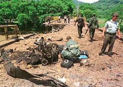 Policías colombianos examinan los restos de un coche bomba colocado por las FARC en La Pintada.