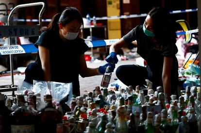 El campus, que se ha convertido en uno de los lugares icónicos de la lucha prodemocrática que protagonizan miles de personas en la urbe desde hace meses, ha quedado convertido en un campo de batalla. En la imagen, dos oficiales de policía examinan las pruebas encontradas, este martes.