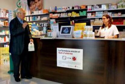 Una farmacéutica atiende a un cliente en una farmacia de Barcelona. EFE/ARchivo