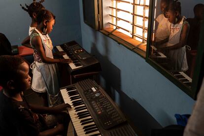 Un grupo de niños y niñas toca dos de los ocho pianos eléctricos con los que cuenta la escuela. Durante las clases, los alumnos aprenden a acompañar a los violinistas. Para Behrens, es muy importante que puedan tocar juntos: “No se trata de que cada uno aprenda a tocar de forma individual, sino de crear unidos y mezclar los instrumentos, de aprender a escuchar, de vivir la experiencia como grupo”, dice.
En sus inicios, la escuela empezó a funcionar en un local de dos habitaciones, con un pequeño grupo sentado en el suelo, porque no había muebles. Tenían cinco violines, cinco ukeleles y un piano. Cuatro años después, hay más de 60 alumnos y cuentan con 50 violines, 15 violonchelos, 20 guitarras, 15 ukeleles, ocho pianos y otros instrumentos como clarinetes, trombones, trompetas, koras, balafones y percusión.