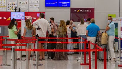 Viajeros con destino al Reino Unido hacen cola para facturar en el aeropuerto de Palma de Mallorca, este domingo.