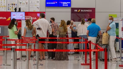 Viajeros con destino al Reino Unido hacen cola para facturar en el aeropuerto de Palma de Mallorca, este domingo.